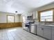 Open kitchen with stainless appliances, gray cabinets, large windows and tile floors at 2021 E 9Th St, Anderson, IN 46012
