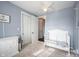 Comfortable bedroom with a crib, dresser, and an open doorway at 208 Coatsville Dr, Westfield, IN 46074