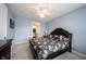 Bright bedroom featuring a queen-size bed, a ceiling fan, carpeted floors and a walk-in closet through the door at 208 Coatsville Dr, Westfield, IN 46074