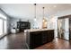 Bright, open-concept kitchen with dark cabinets, island, and stainless steel appliances overlooks the living area at 208 Coatsville Dr, Westfield, IN 46074