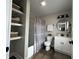 Charming bathroom features a shower-tub combo, floating shelves, modern fixtures, and a gray color scheme at 220 Huffman Rd, Columbus, IN 47201