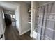 Well-lit bathroom with a shower and tub, gray shower curtain, and built-in shelving for storage at 220 Huffman Rd, Columbus, IN 47201