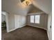 Cozy carpeted bedroom features an exposed beam ceiling, bright windows, and neutral paint at 220 Huffman Rd, Columbus, IN 47201