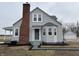 Charming two-story home with a brick chimney, detached garage, and landscaped yard at 220 Huffman Rd, Columbus, IN 47201