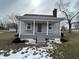 Inviting exterior showcasing a covered porch with seating, gray siding and updated landscaping at 220 Huffman Rd, Columbus, IN 47201
