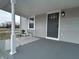 Relaxing front porch with comfortable seating, stylish rug, and views of the surrounding landscape at 220 Huffman Rd, Columbus, IN 47201