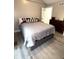 Bedroom featuring a bed with neutral bedding, a dark wood dresser, and wood-look flooring at 2284 Horizon Blvd, Greenwood, IN 46143
