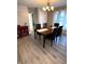 Dining room with wood-look floors, adjacent to a living area, and a red cabinet in the background at 2284 Horizon Blvd, Greenwood, IN 46143