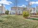 Lush backyard featuring a well-maintained lawn, mature trees, and a covered deck area at 2311 Lammermoor Ln, Indianapolis, IN 46214