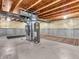 Unfinished basement featuring concrete walls, exposed wood beams, and utilities at 2311 Lammermoor Ln, Indianapolis, IN 46214