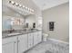 Bright bathroom featuring marble floors, granite counters, a soaking tub, and built-in shelving at 2311 Lammermoor Ln, Indianapolis, IN 46214