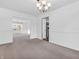 Bright dining room featuring neutral carpet, chandelier lighting, and convenient access to the kitchen at 2311 Lammermoor Ln, Indianapolis, IN 46214
