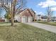 Beautiful home with a well-kept lawn, mature trees, and a paved driveway leading to a garage at 2311 Lammermoor Ln, Indianapolis, IN 46214