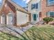 Close-up view of a brick home's entrance, showcasing a well-kept lawn and charming details at 2311 Lammermoor Ln, Indianapolis, IN 46214