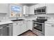 Updated kitchen with stainless steel appliances, white cabinetry, and abundant natural light at 2311 Lammermoor Ln, Indianapolis, IN 46214