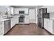 Updated kitchen featuring stainless steel appliances, white cabinetry, and hardwood floors at 2311 Lammermoor Ln, Indianapolis, IN 46214