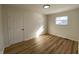 Bedroom features wood floors, light colored walls, modern light fixture, and windows with natural light at 2411 N Kitley Ave, Indianapolis, IN 46219
