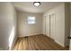 Bedroom with wood floors, light colored walls, modern light fixture, window, and closet at 2411 N Kitley Ave, Indianapolis, IN 46219