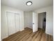 Bedroom with wood floors, light colored walls, modern light fixture, closet, and a door frame at 2411 N Kitley Ave, Indianapolis, IN 46219