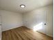 Bedroom with wood floors, light colored walls, modern light fixture, door, and windows with natural light at 2411 N Kitley Ave, Indianapolis, IN 46219
