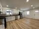 Modern kitchen with stainless steel appliances, white cabinets, and spacious layout with sleek wood flooring at 2411 N Kitley Ave, Indianapolis, IN 46219