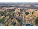 An aerial view shows homes nestled among mature trees with long driveways, surrounded by fields, creating a rural community at 24535 Jerkwater Rd, Sheridan, IN 46069