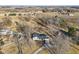 An aerial view showcasing the home's setting among the trees, outbuildings, and circular drive at 24535 Jerkwater Rd, Sheridan, IN 46069