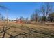 Red barn sits amongst the trees with a playground set in the background at 24535 Jerkwater Rd, Sheridan, IN 46069