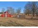 Rustic red barn on a sprawling lot surrounded by trees, perfect for hobby farming or storage at 24535 Jerkwater Rd, Sheridan, IN 46069