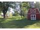 View of a bright red barn with white trim surrounded by a green grassy yard at 24535 Jerkwater Rd, Sheridan, IN 46069