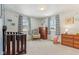 Bright Bedroom featuring a crib, dresser, rocking chair, and windows with striped curtains at 24535 Jerkwater Rd, Sheridan, IN 46069