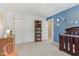 Blue accent wall bedroom featuring a crib, closet, and decorative bookshelf at 24535 Jerkwater Rd, Sheridan, IN 46069