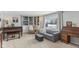 Inviting living room with a stylish gray sofa, custom built-ins, large windows, piano, and a cozy ottoman at 24535 Jerkwater Rd, Sheridan, IN 46069