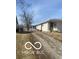 Gravel driveway leading to a single story home under a clear, blue sky at 2454 Winfield Ave, Indianapolis, IN 46222