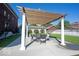 Backyard concrete patio featuring a wooden pergola, seating, and a well-manicured lawn at 3034 N Pennsylvania St # 1, Indianapolis, IN 46205