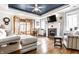 Comfortable living room with fireplace, tray ceiling, hardwood floors, and access to sunroom at 3034 N Pennsylvania St # 1, Indianapolis, IN 46205