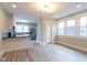 Open dining room showcasing stylish gray wood floors, modern light fixture, and connected to the kitchen at 3419 Carrollton Ave, Indianapolis, IN 46205