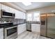 Modern kitchen featuring stainless steel appliances, sleek black countertops, and unique patterned backsplash at 3419 Carrollton Ave, Indianapolis, IN 46205