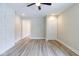Bright living room featuring stylish gray wood floors, modern ceiling fan, and updated white wall at 3419 Carrollton Ave, Indianapolis, IN 46205