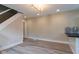 Bright living room featuring stylish gray wood floors, modern staircase, and adjacent to kitchen at 3419 Carrollton Ave, Indianapolis, IN 46205