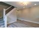 Bright living room featuring stylish gray wood floors, modern staircase, and updated lighting at 3419 Carrollton Ave, Indianapolis, IN 46205