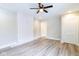 Bright living room featuring stylish gray wood floors, modern ceiling fan, and updated white wall at 3419 Carrollton Ave, Indianapolis, IN 46205