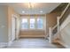 Bright living room featuring stylish gray wood floors, modern staircase, and updated lighting at 3419 Carrollton Ave, Indianapolis, IN 46205