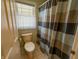 Standard bathroom with a toilet, tile floor, and shower with a decorative curtain and a window at 3681 S Station Dr, Columbus, IN 47203