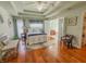 Spacious bedroom with hardwood floors, a tray ceiling with a ceiling fan, and a view to the bathroom at 3681 S Station Dr, Columbus, IN 47203