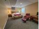 Finished basement bedroom with a queen sized bed, side tables, and a comfortable chair and ottoman at 3681 S Station Dr, Columbus, IN 47203