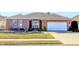 Charming single-story brick home featuring a manicured lawn and a two-car garage at 3681 S Station Dr, Columbus, IN 47203
