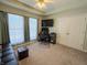 Carpeted home office with large window, ceiling fan, and leather sofa with decorative pillows at 3681 S Station Dr, Columbus, IN 47203