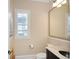 Charming powder room with a framed mirror, window with blinds, and tasteful decor at 3841 Falls Cir, Carmel, IN 46033