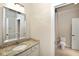 Bright bathroom featuring a decorative mirror, granite countertops, and a view to the toilet room at 3841 Falls Cir, Carmel, IN 46033